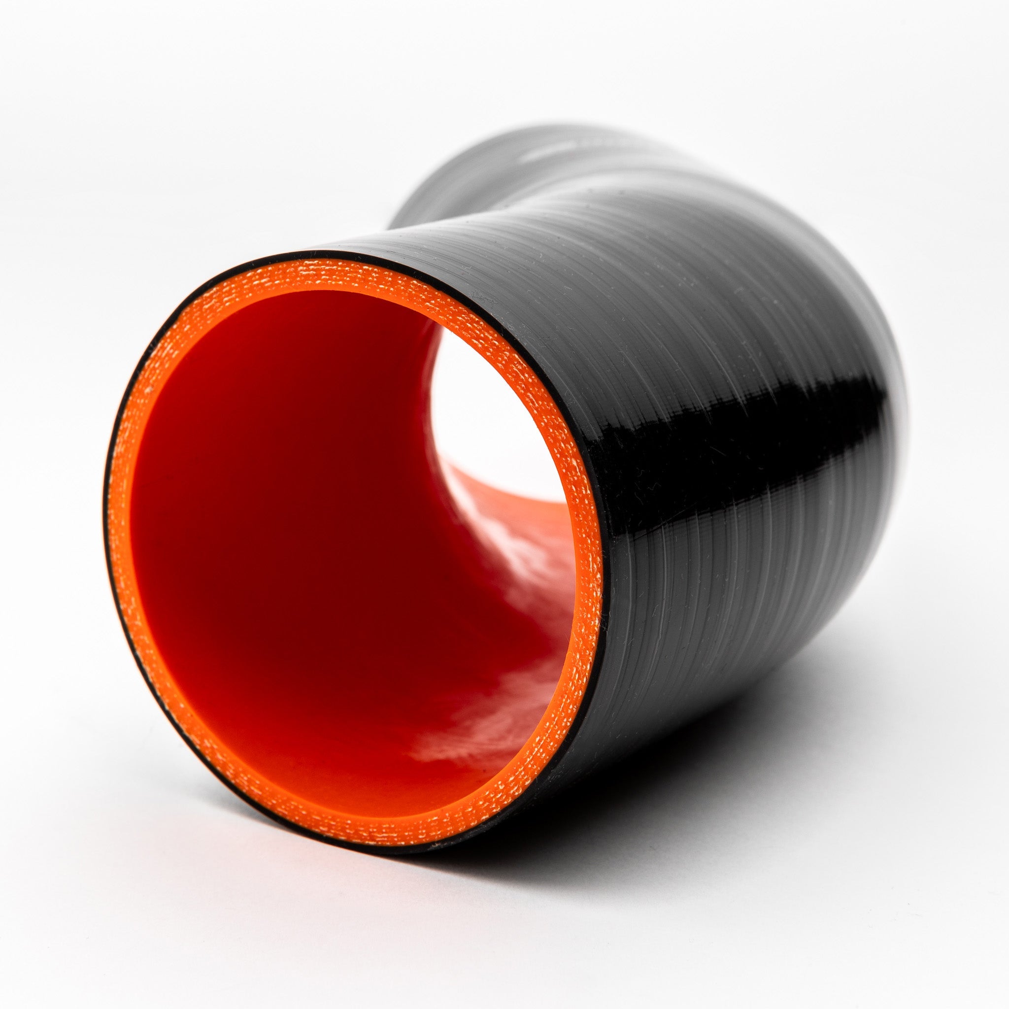 Black silicone hose with red interior on a white background