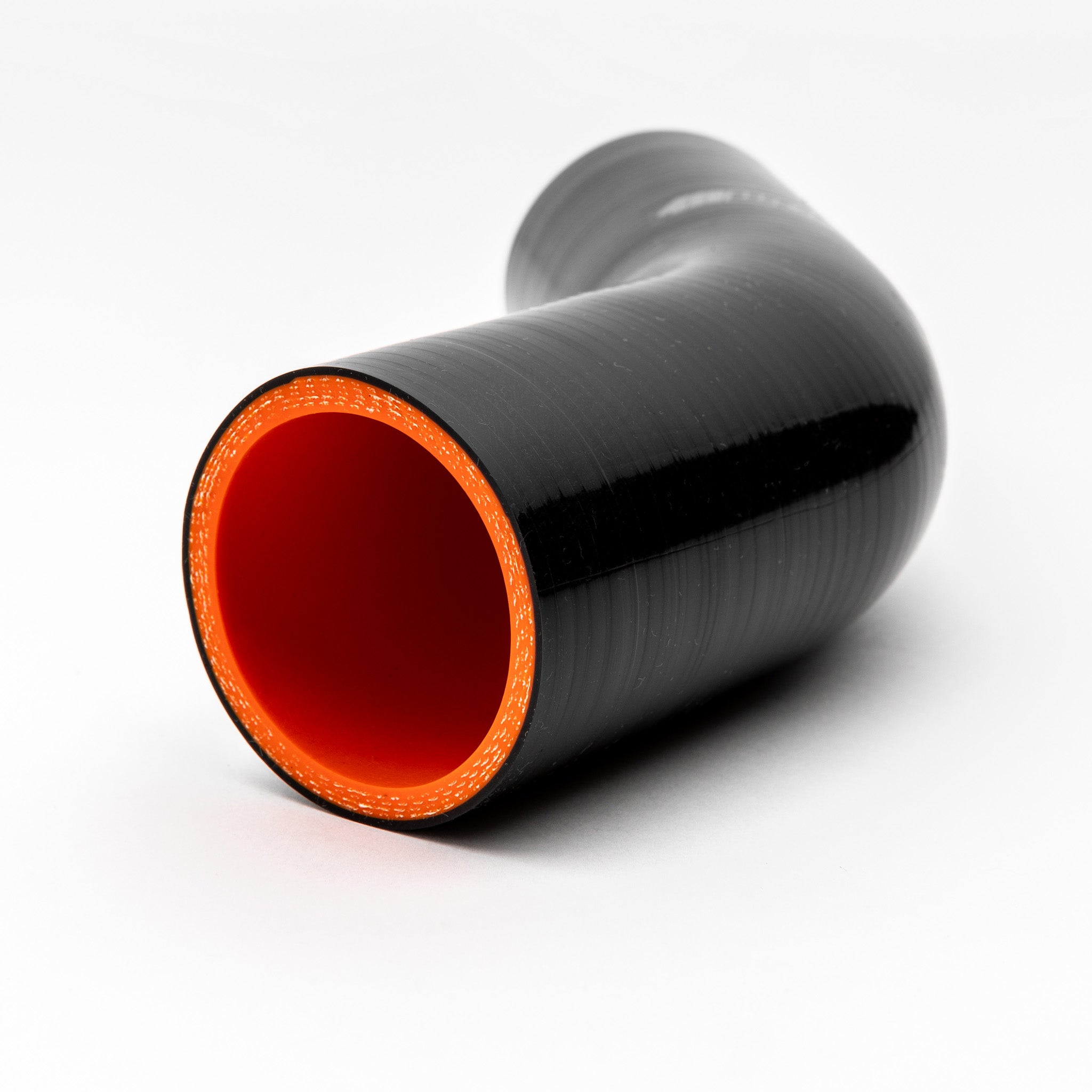 Black silicone hose with orange interior on a white background