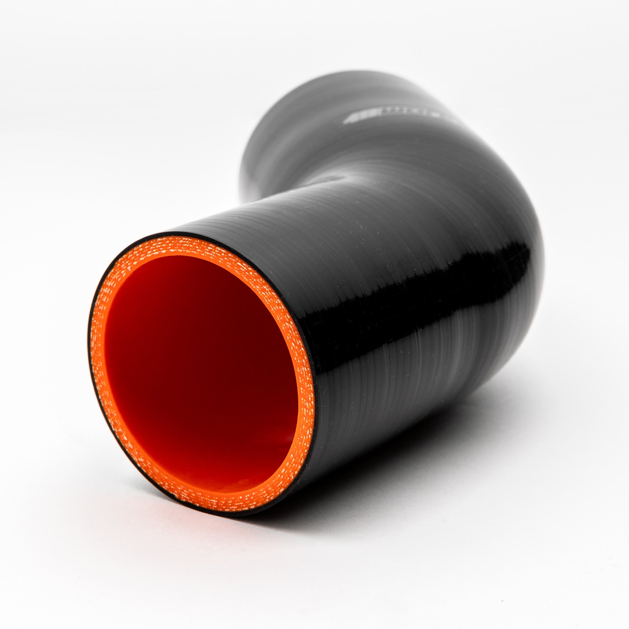 Black silicone reducer with red interior on a white background