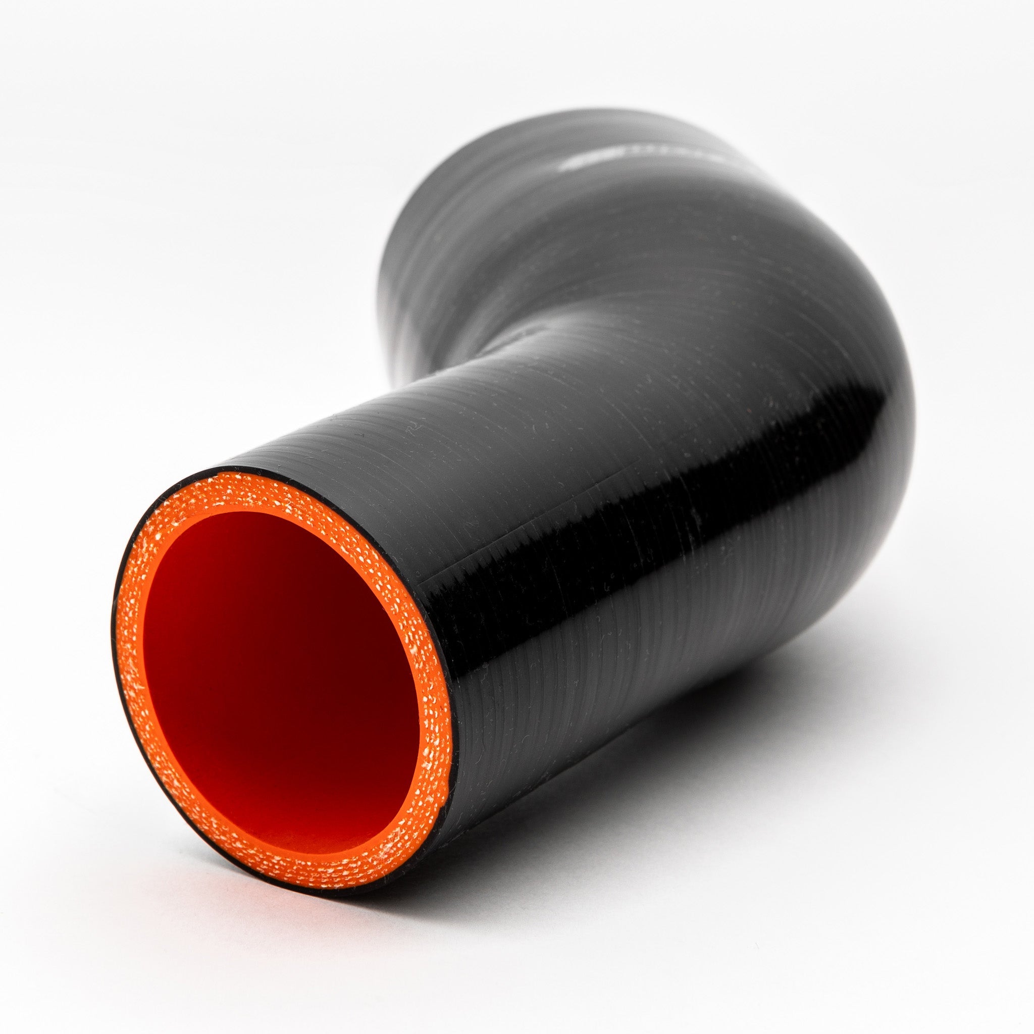 Black silicone reducer with red interior on a white background