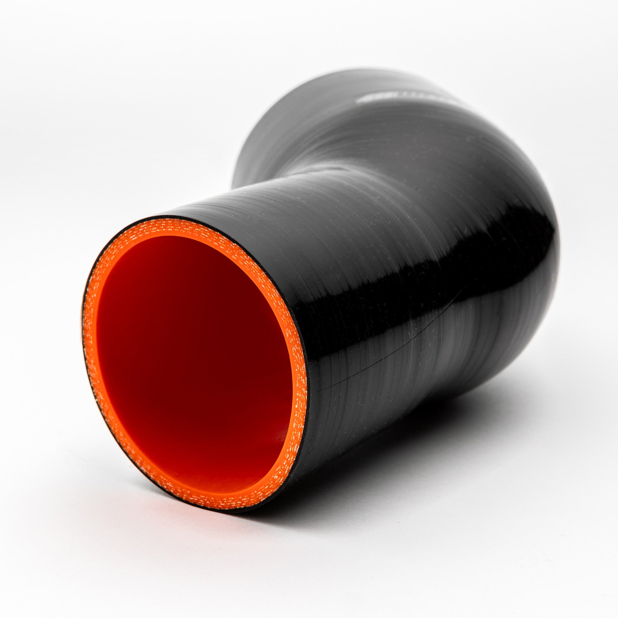 Black silicone reducer with red interior on a white background
