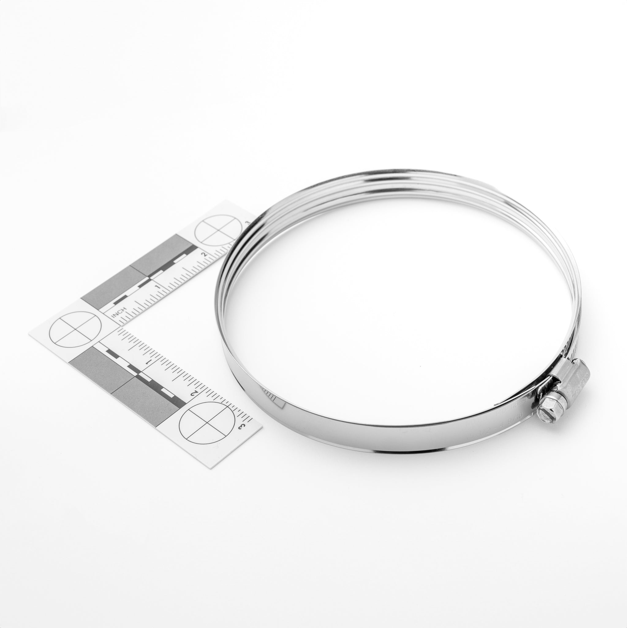 Silver clamp with a ruler for size reference on a white background