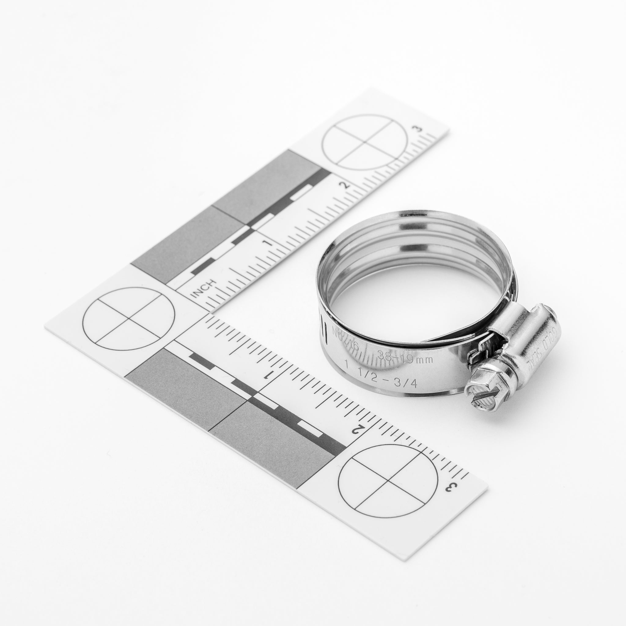 Metal clamp on a white background with a ruler for scale