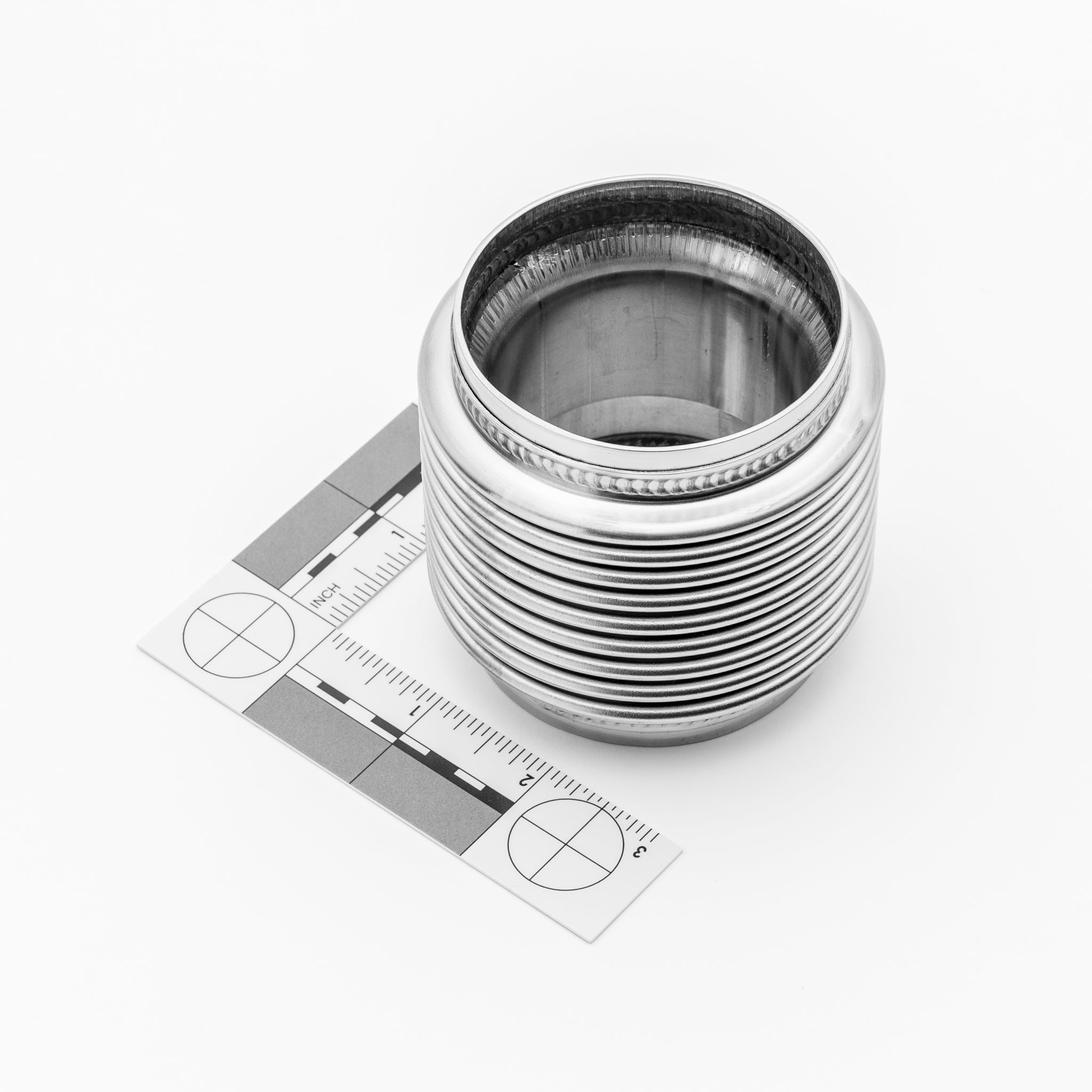 Metallic exhaust bellow with concentric rings on a white background