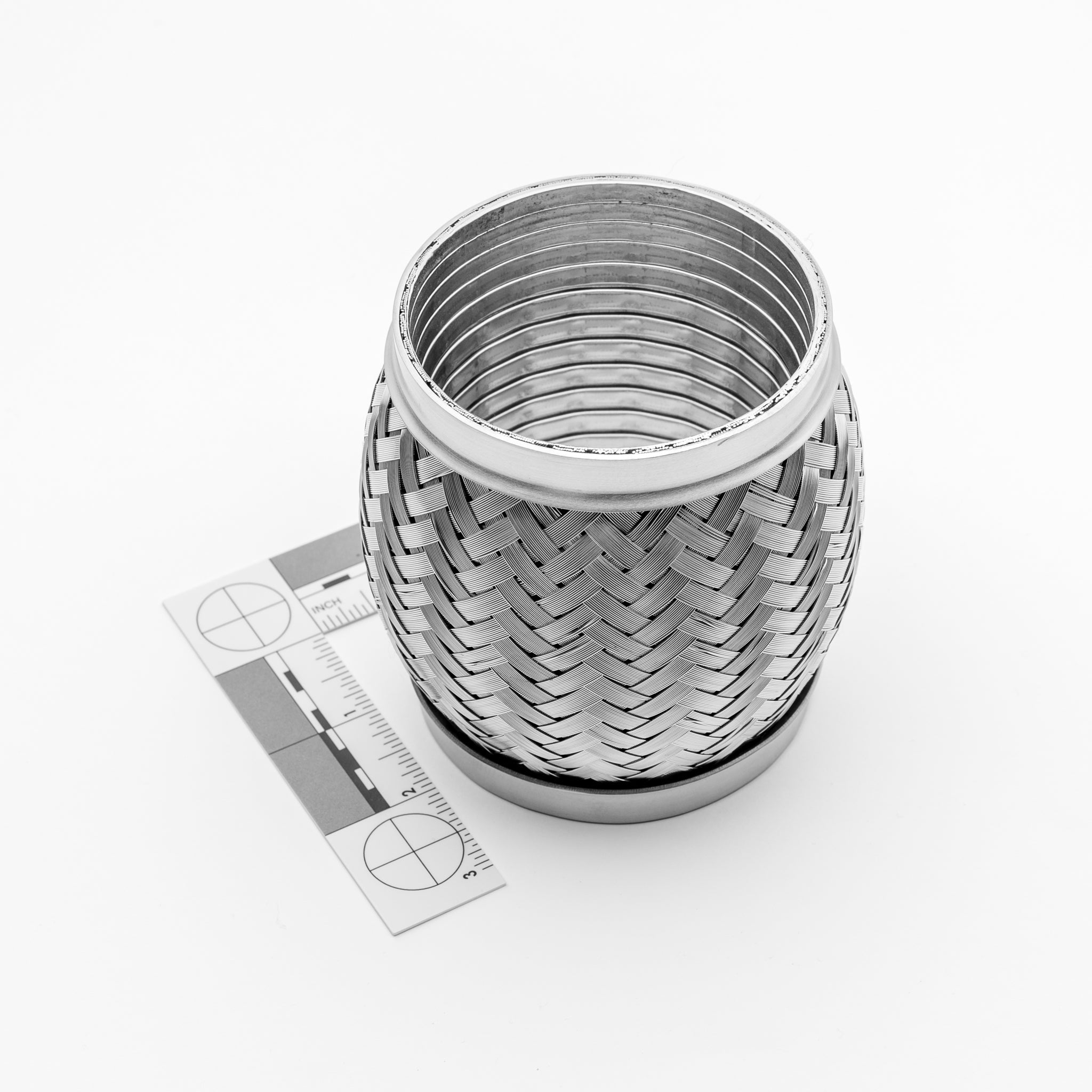 Exhaust flex joint with a ruler for scale on a white background