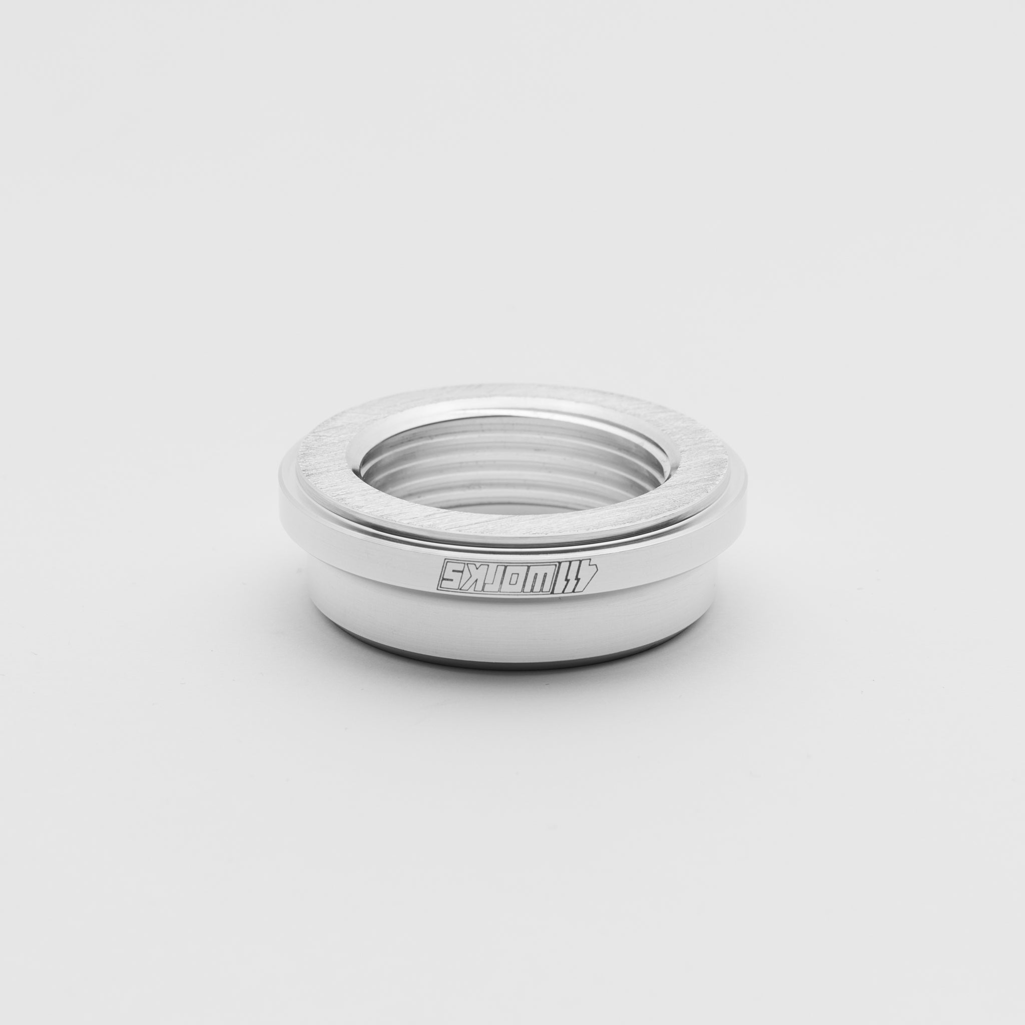 Silver ring with '411 Works' branding on a light gray background