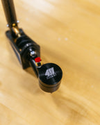 Close-up of a black and red reservoir on a wooden surface