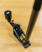 Black metal lever with red and gold accents on a wooden surface