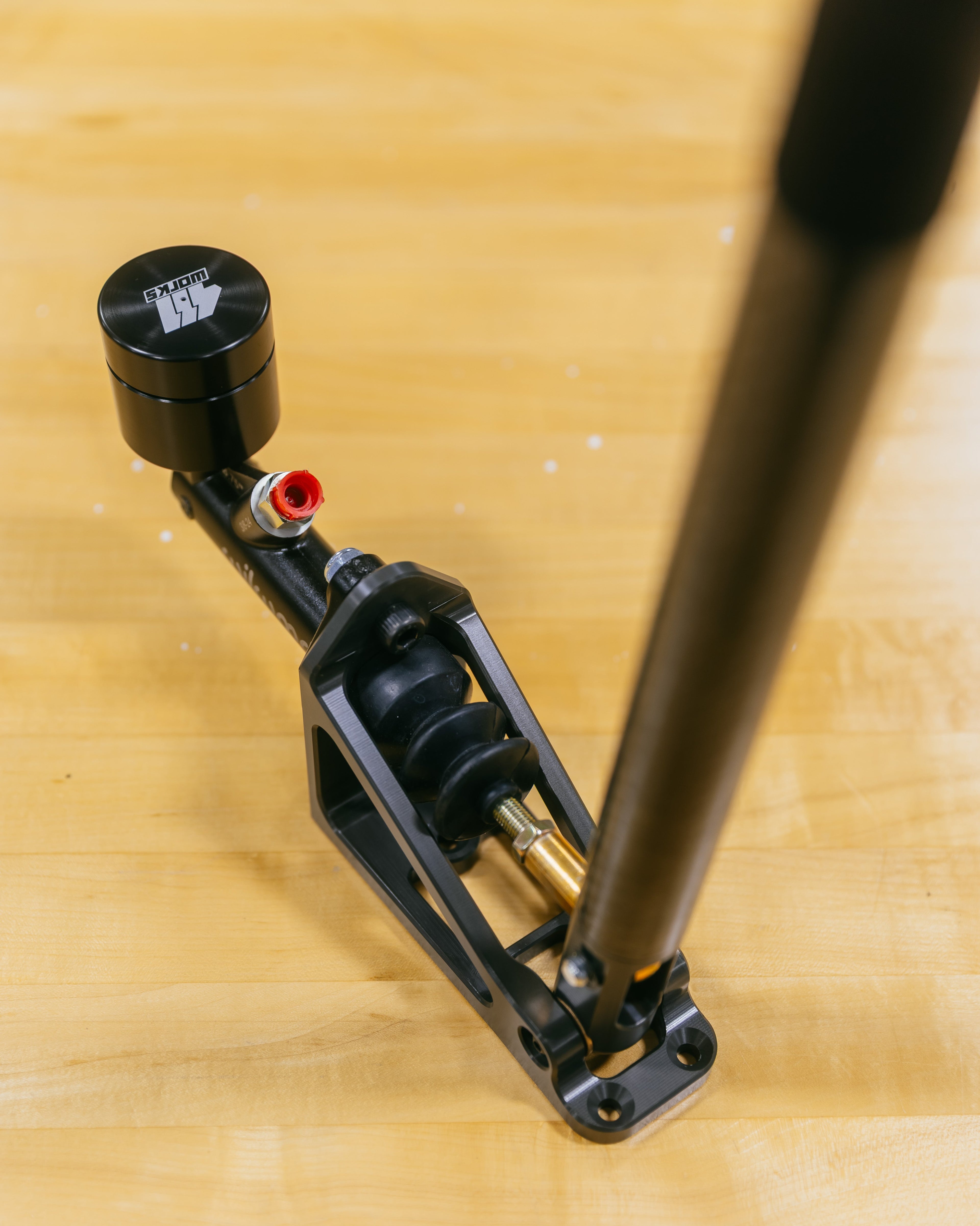 Black metal lever with red and gold accents on a wooden surface