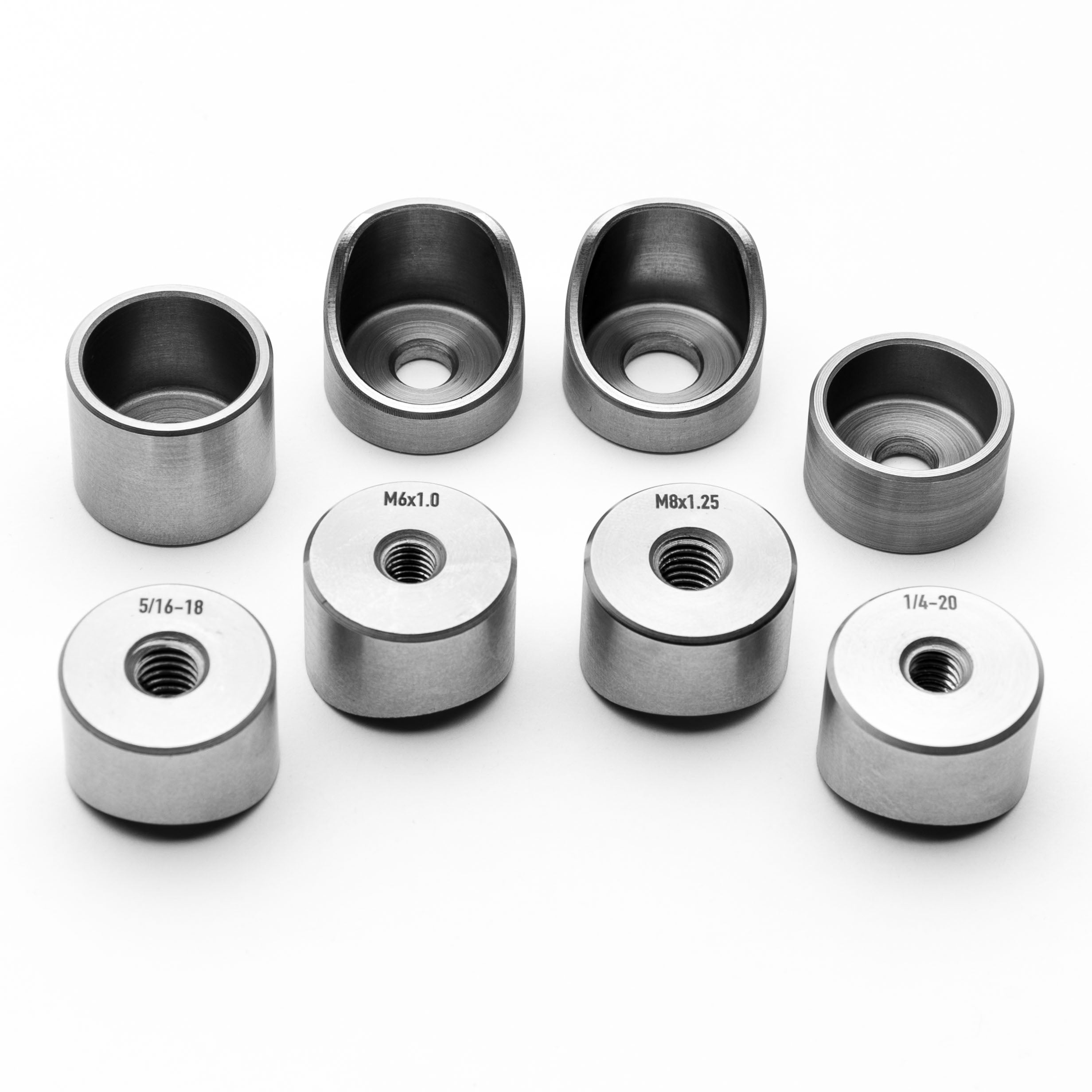 Set of coped weld bungs with various sizes on a white background