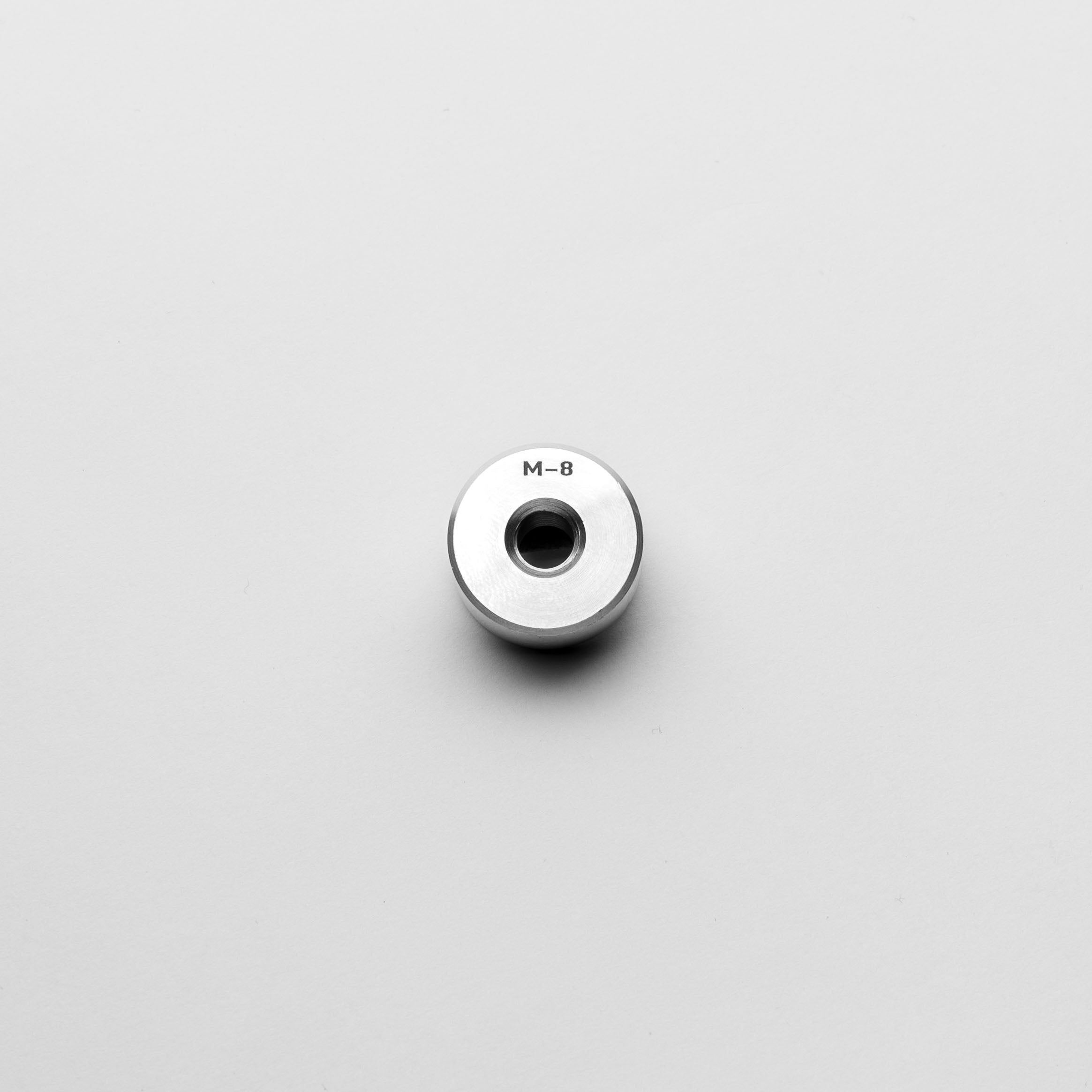 Metallic bungs with 'M-8' marking on a light gray background