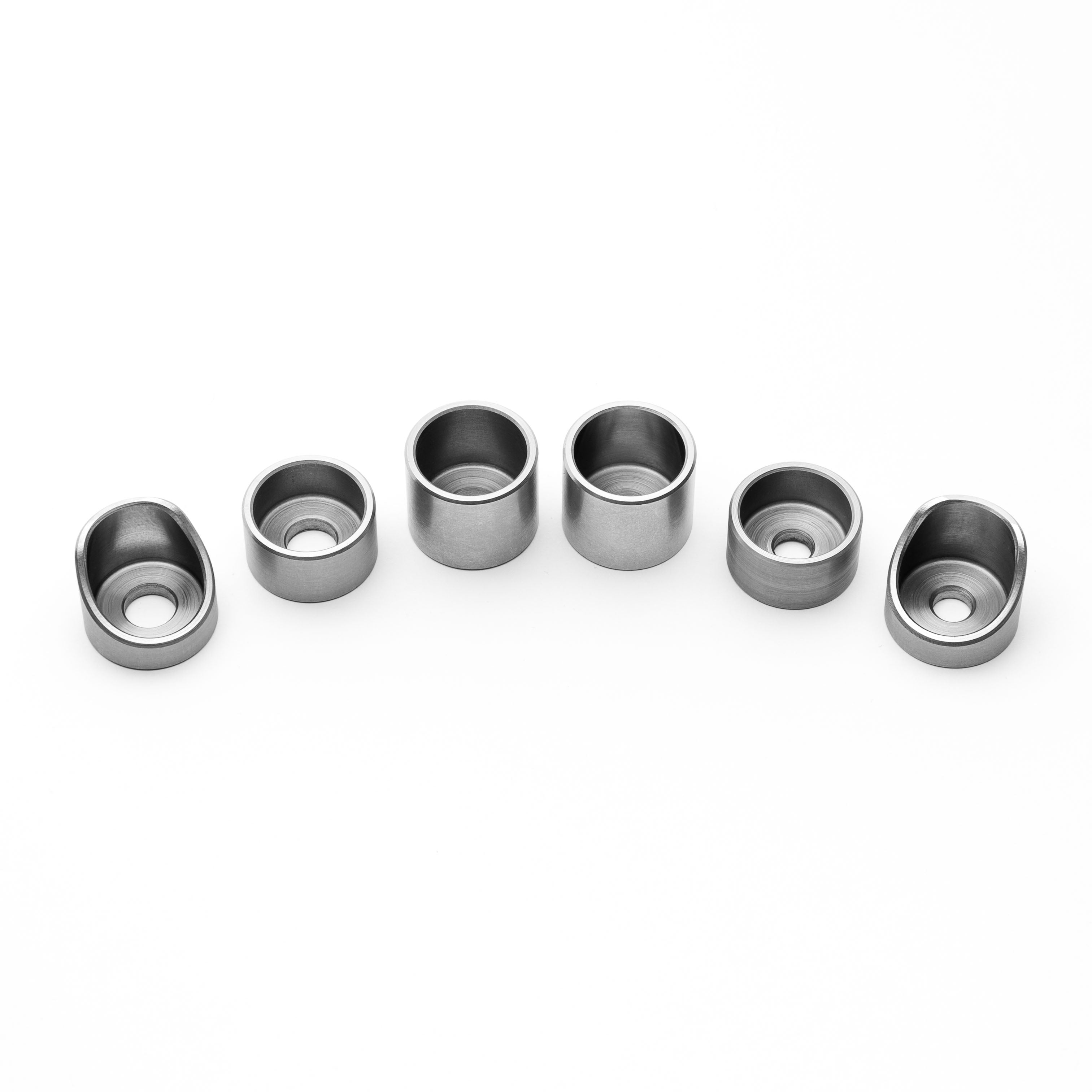 Set of six metallic weld cup components on a white background