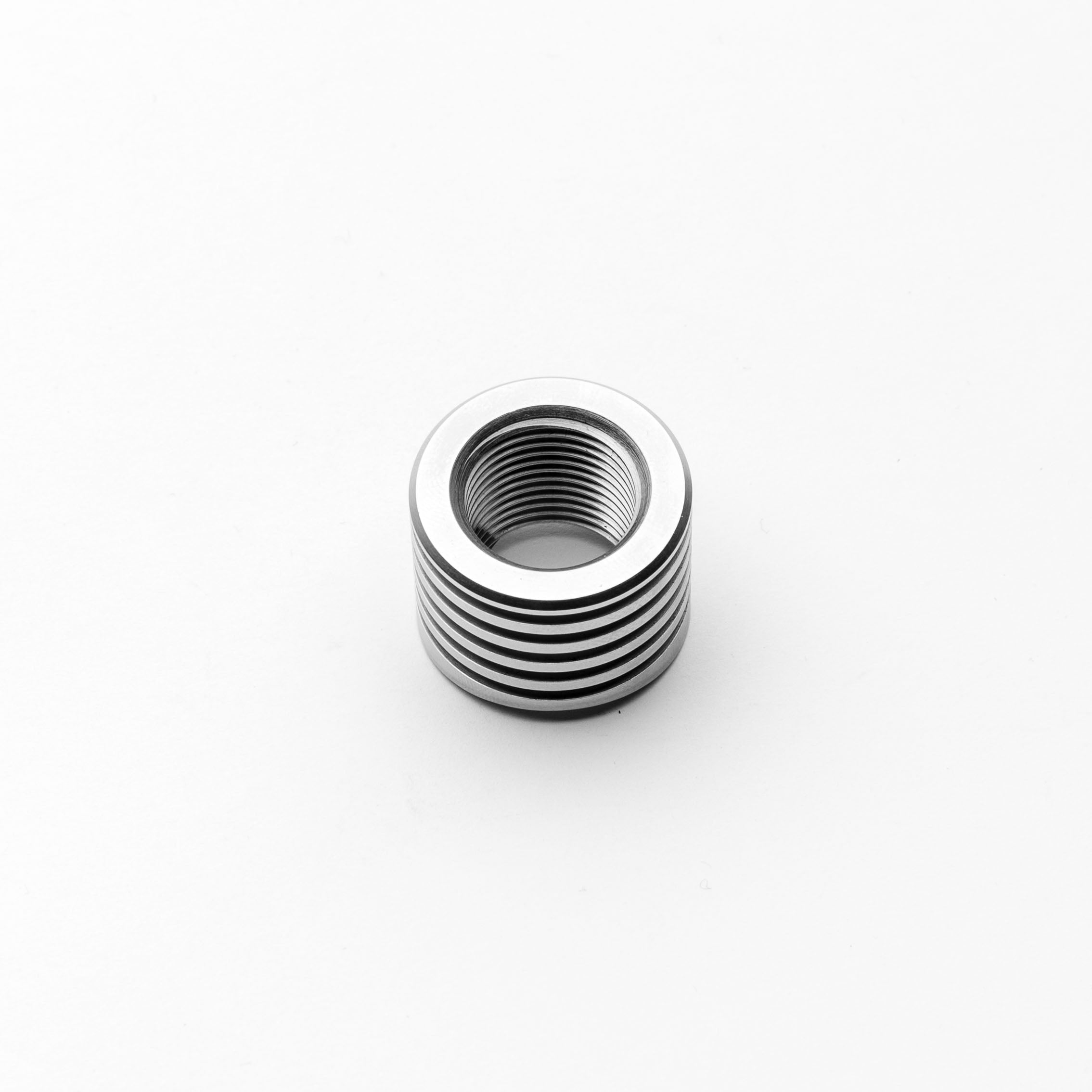 Metallic threaded cylindrical object on a white background