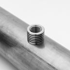 Metallic thread insert on a metal pipe with a white background
