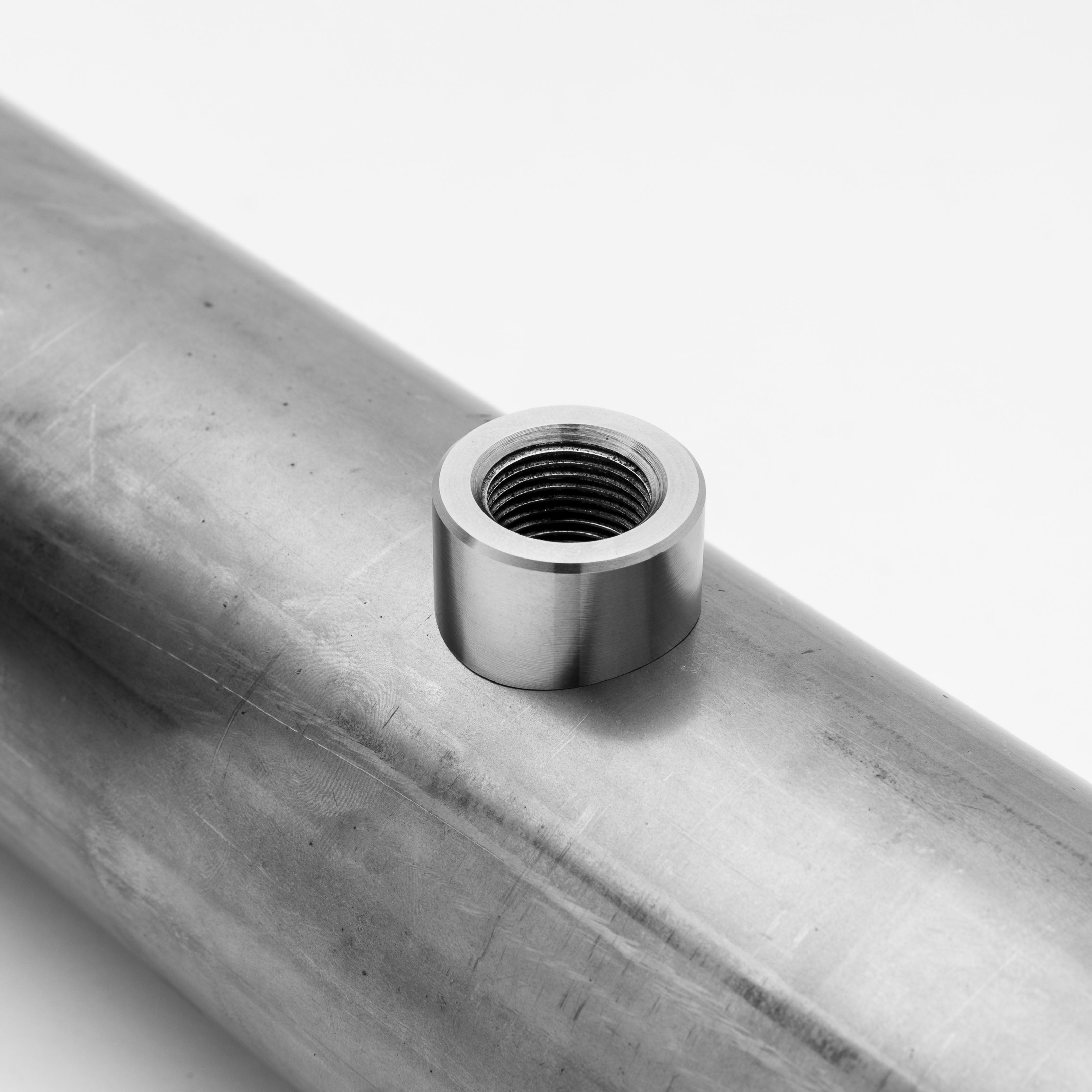 Metallic fitting on a 02 bung non heat sink with a white background
