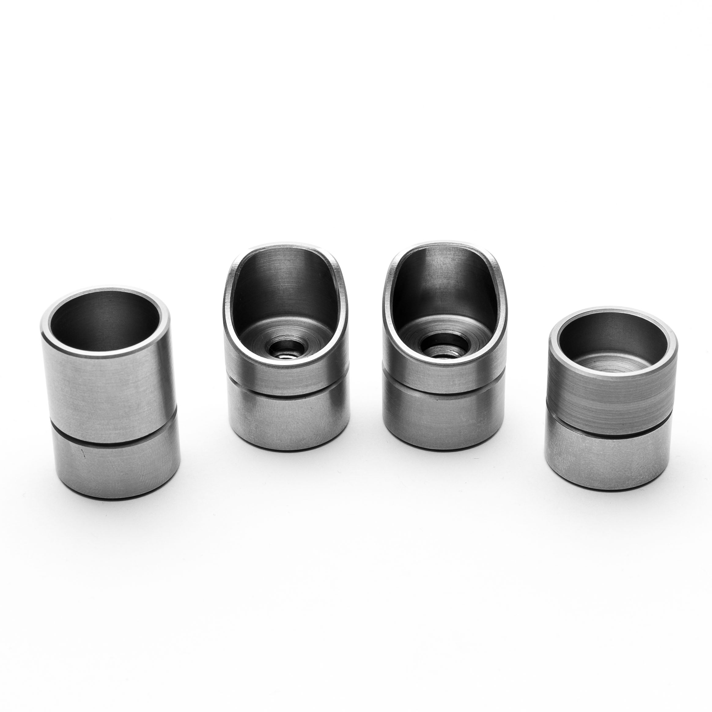 Four metallic steel threaded bungs on a white background