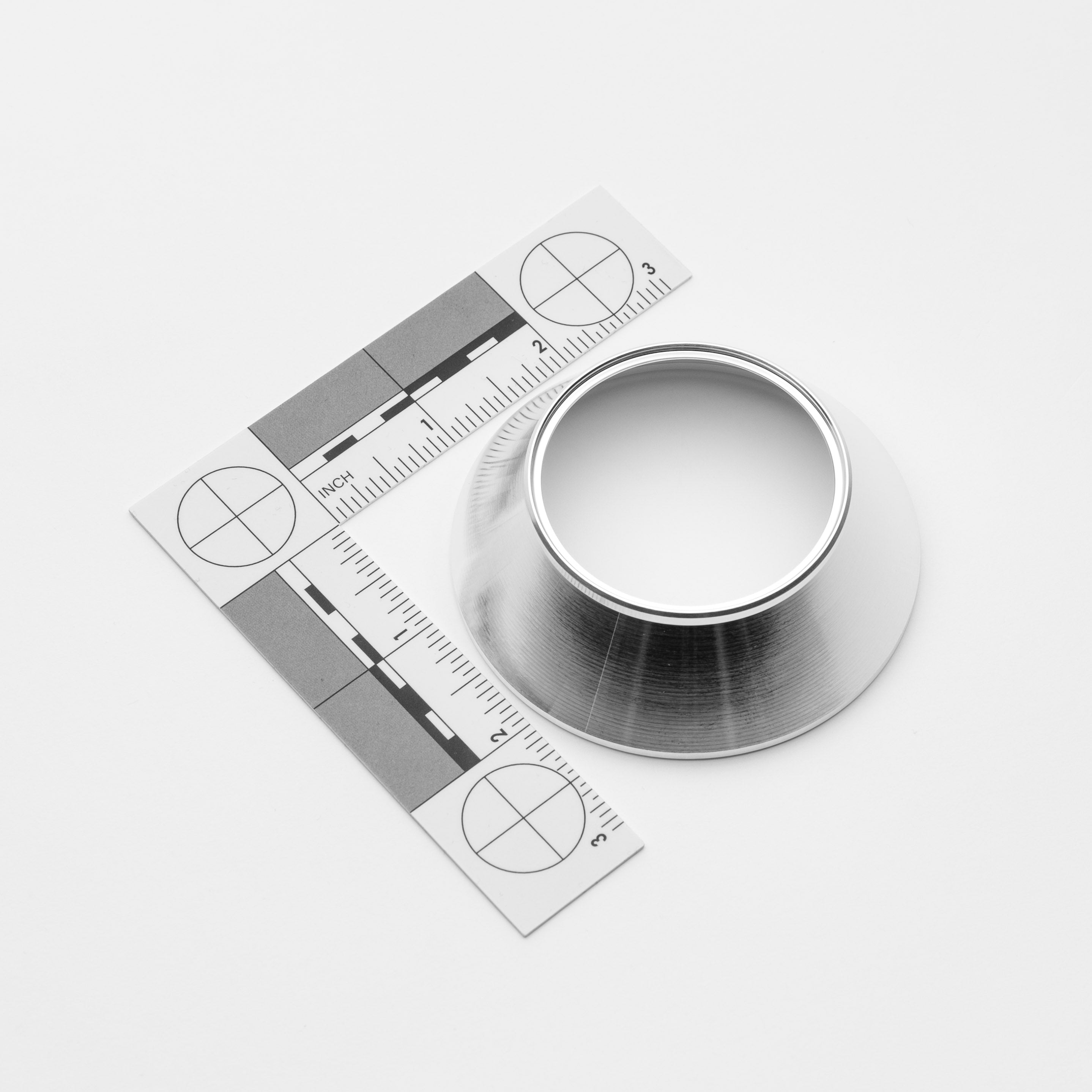Metallic reducers with a ruler for scale on a white background