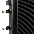 Close-up of a black radiator with metallic connectors on a white background