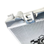 Close-up of a metallic radiator with a brand logo on a white background