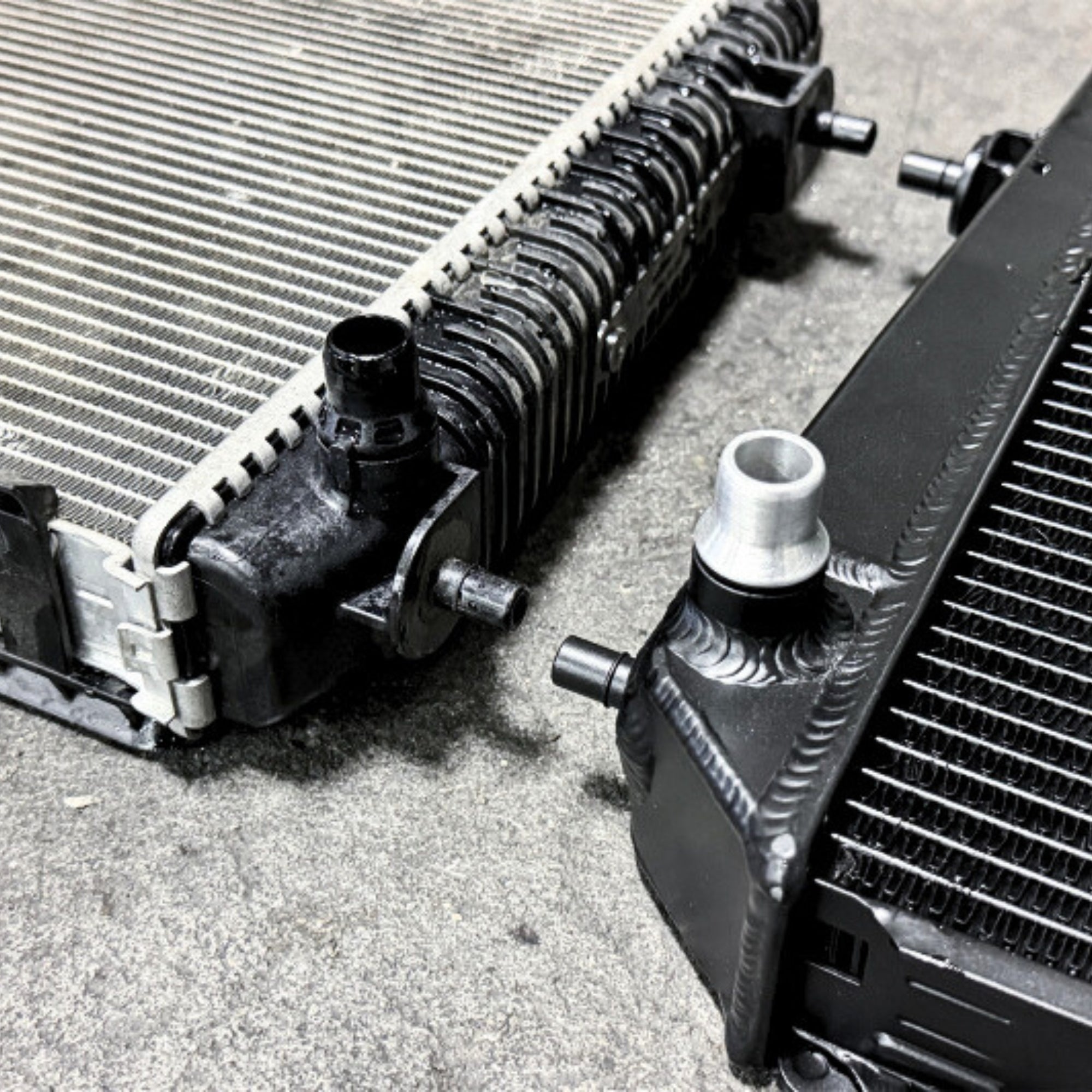 Close-up of two automotive radiators on a concrete surface