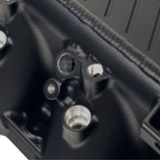 Close-up of a black mechanical component with threaded ports