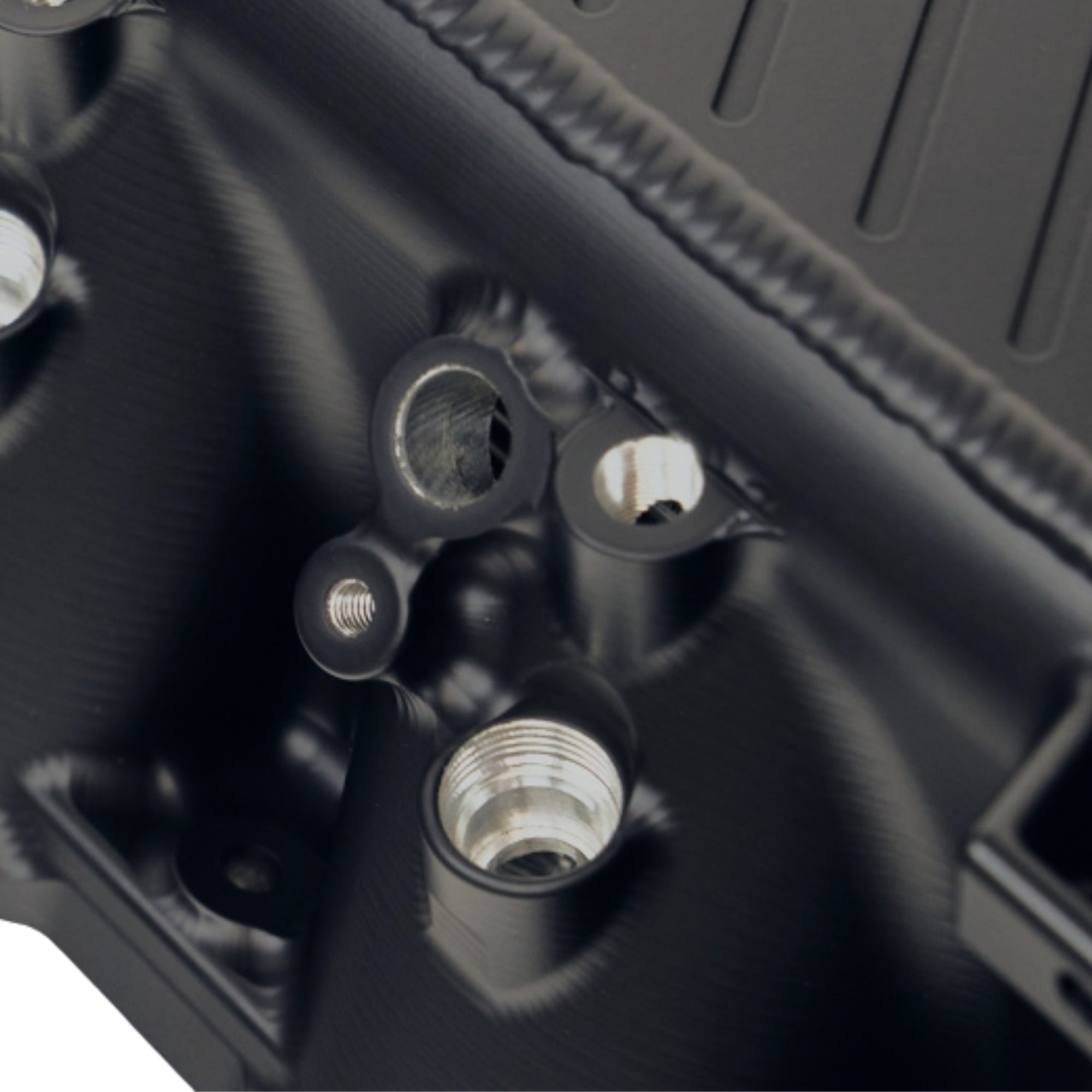 Close-up of a black mechanical component with threaded ports