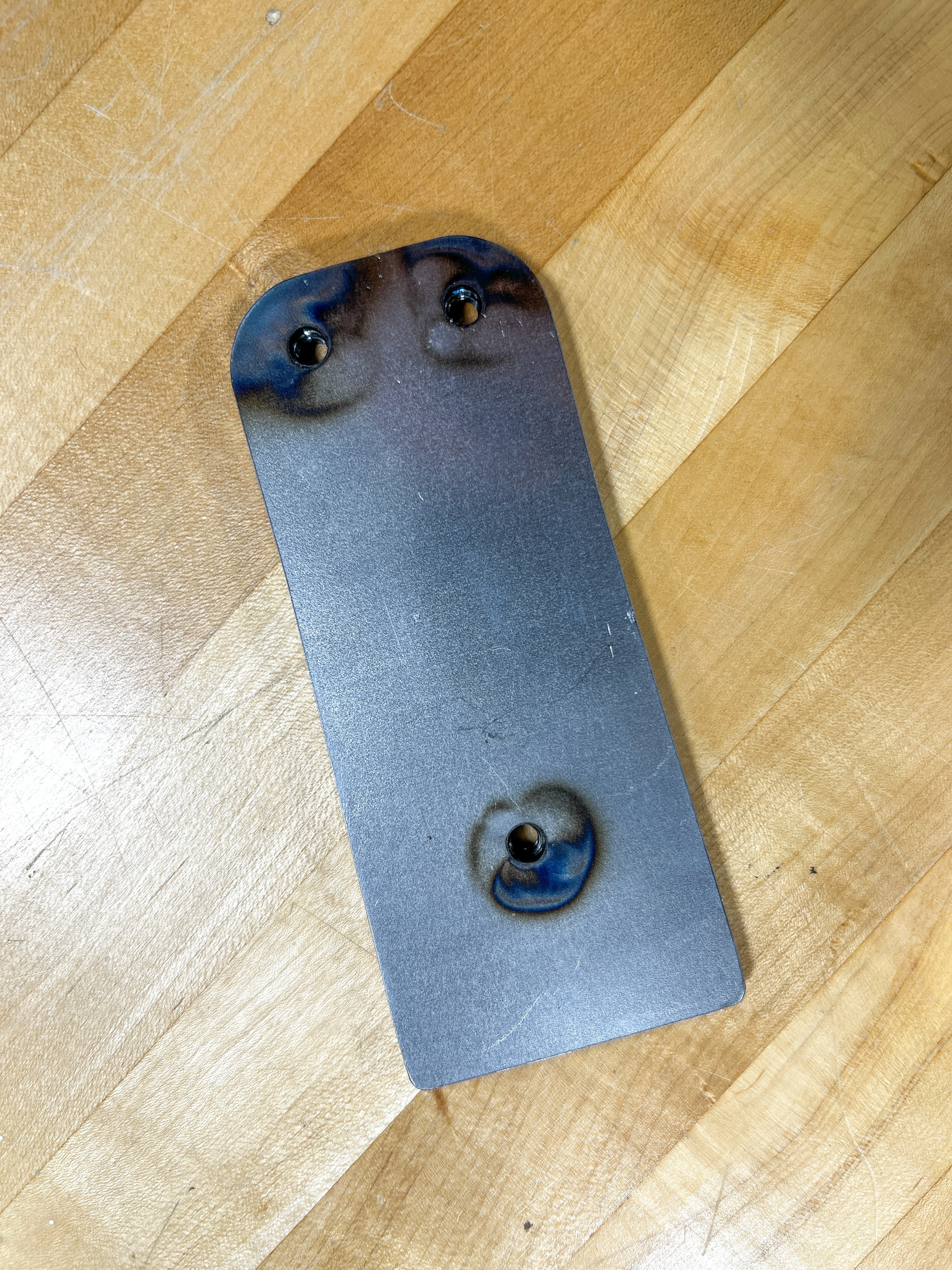 Metal plate with holes on a wooden floor