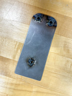 Metal bracket with three screws on a wooden surface