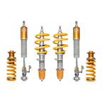 Set of Ohlins suspension components with yellow springs and orange shock absorbers on a white background