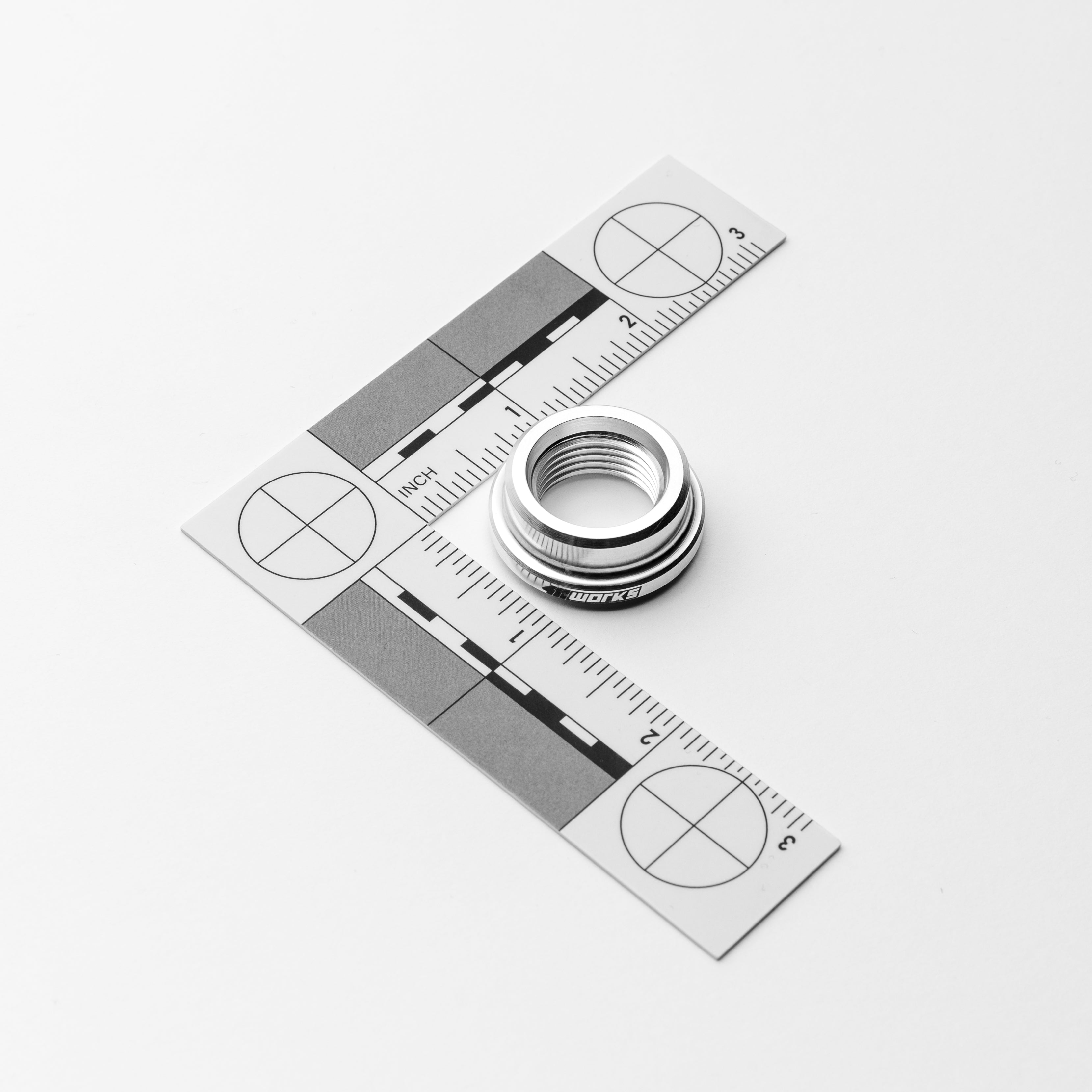 Metallic circle and ruler on a white background